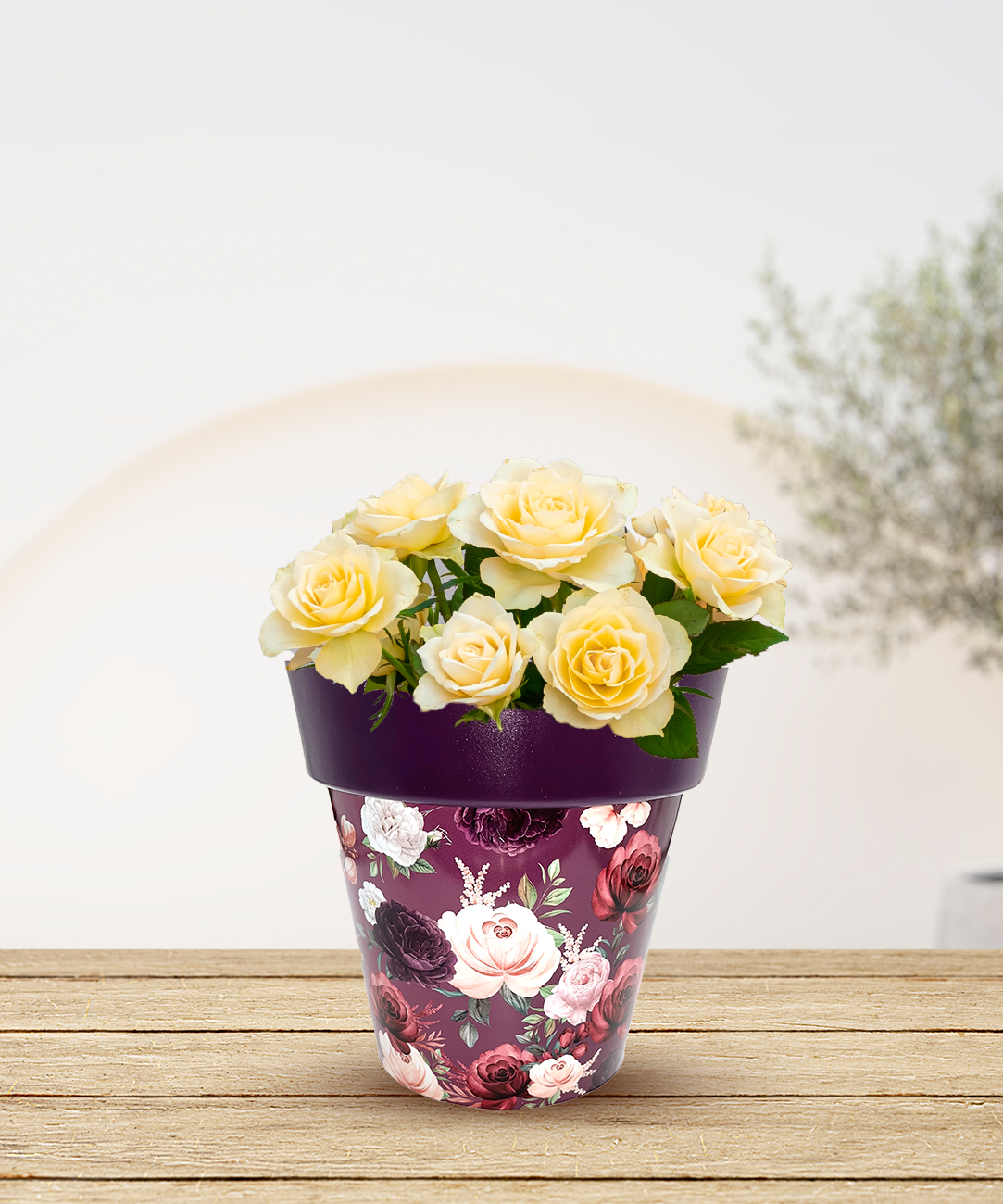 a pink vase filled with yellow flowers on a wooden table 